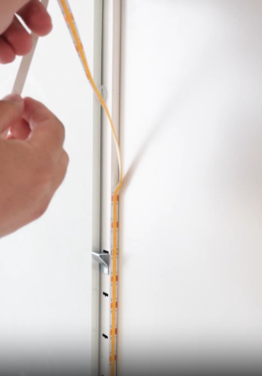 Installing LED strip into the aluminum mounting track of a display box wall