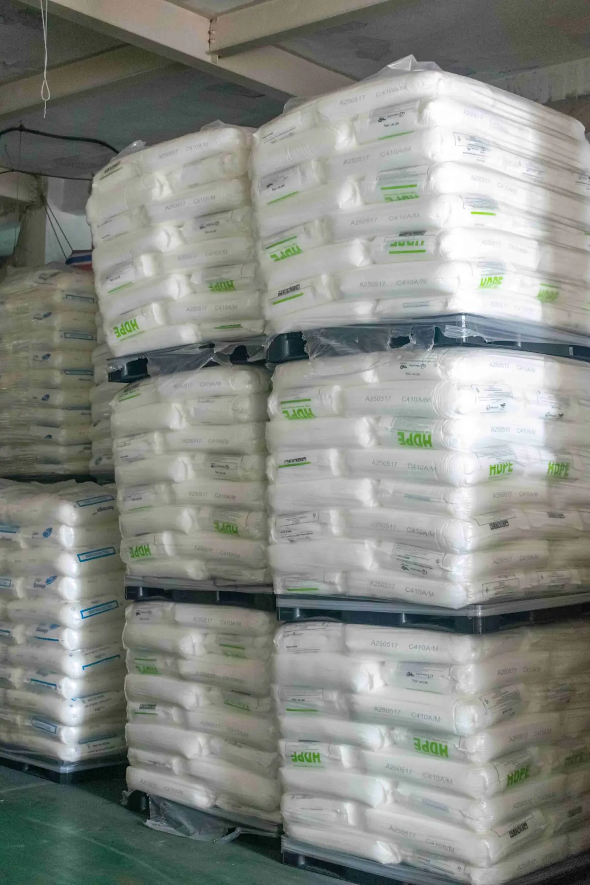 Stacked bags of plastic raw material pellets used for display box production